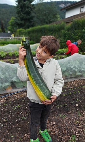 Kind mit großer Zucchini